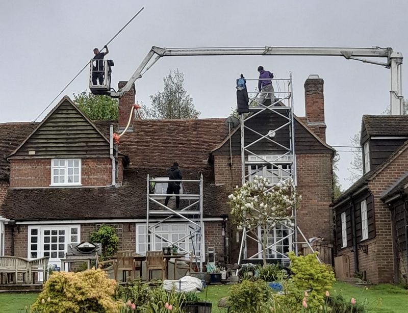 The Moss Cleaners using cherry picker and scaffolding to clean roof safely and professionally in Innsworth, Gloucestershire